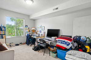Office space with carpet flooring and a textured ceiling