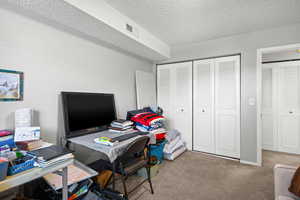 Office with carpet and a textured ceiling