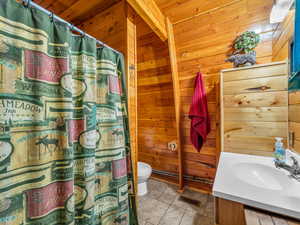 Full bathroom with wooden walls, vanity, tile patterned flooring, curtained shower, and wooden ceiling