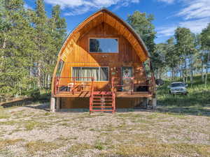Rear view of property with stairs and a deck