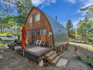 Rear view of house with a gambrel roof and a deck