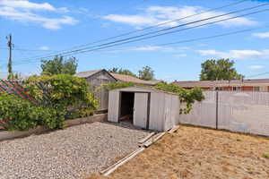 Fenced backyard featuring a storage shed