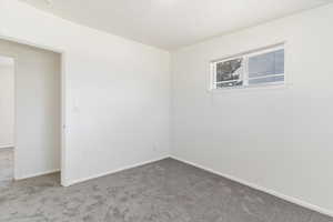 Carpeted spare room with baseboards