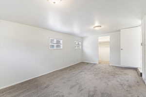 Unfurnished room featuring light colored carpet and baseboards