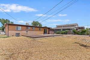 Back of house featuring brick siding and a wooden deck