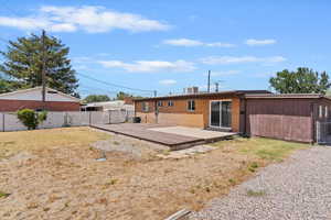 Back of property with a wooden deck and brick siding