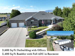 View of front facade with a mountain view, brick siding, driveway, roof with shingles, and a garage