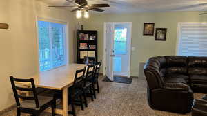 Dining room featuring ceiling fan, carpet floors, a textured ceiling, and healthy amount of natural light