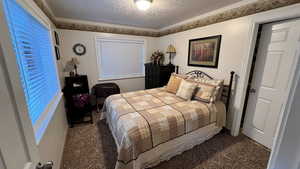 Carpeted bedroom featuring a textured ceiling
