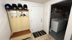 Washroom featuring washer and dryer and stone finish flooring
