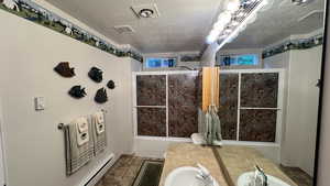 Full bath featuring a textured ceiling and vanity