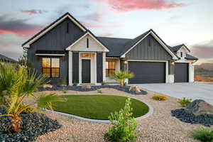 Modern farmhouse featuring board and batten siding, concrete driveway, a garage, and a front yard