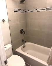 Full bathroom with toilet and shower / washtub combination