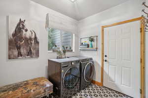 Laundry area with washing machine and clothes dryer and baseboards