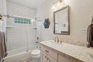 Full bathroom featuring vanity and shower / bath combination with glass door