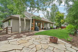Back of property featuring an outdoor fire pit, a patio, a fenced backyard, and roof with shingles