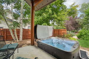 Fenced backyard with a hot tub and a patio area