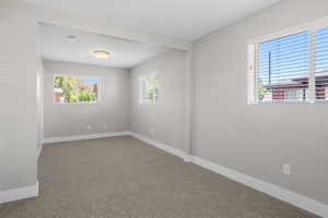 Empty room featuring carpet and a smoke detector
