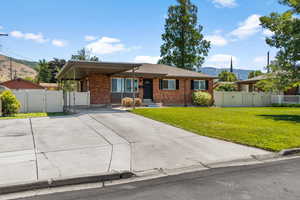 Single story home featuring a gate, a mountain view, brick siding, and driveway