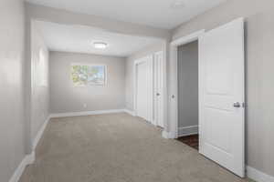 Unfurnished bedroom with light carpet and a closet