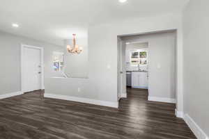 Unfurnished room featuring a chandelier, dark wood-style floors, healthy amount of natural light, and recessed lighting