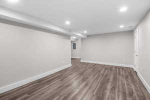 Finished below grade area featuring recessed lighting, dark wood finished floors, and electric panel