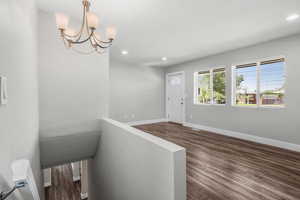 Foyer entrance featuring recessed lighting, dark wood-type flooring, and a chandelier