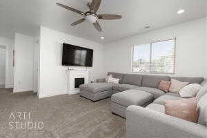 Carpeted living room with ceiling fan, recessed lighting, and a fireplace