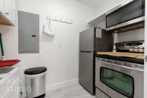 Upstairs kitchen with stainless steel appliances, white cabinets, and light countertops
