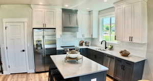 Kitchen with appliances with stainless steel finishes, backsplash, premium range hood, gray cabinetry, and recessed lighting