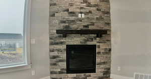 Detailed view of baseboards and a stone fireplace