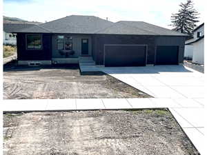 Ranch-style house with driveway, a garage, and a shingled roof