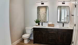 Bathroom featuring double vanity and wood finished floors
