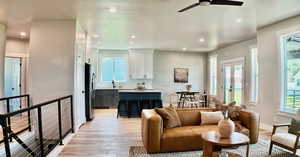 Living room with recessed lighting, light wood-style flooring, and a ceiling fan