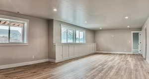 Empty room with light wood finished floors and recessed lighting
