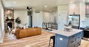 Kitchen with stainless steel appliances, open floor plan, a ceiling fan, recessed lighting, and a center island