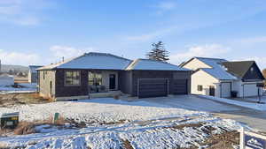 Ranch-style home featuring an attached garage, concrete driveway, and brick siding