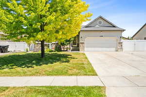 View of front of home with a gate, driveway, an attached garage, and stucco siding