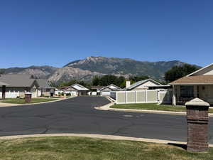 View of asphalt street featuring a mountain view, a residential view, and a gate