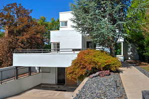 View of front of house with a balcony and stucco siding