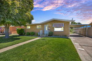 Single story home with a carport, driveway, and brick siding