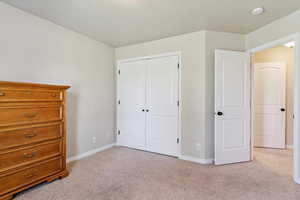 Bedroom featuring light carpet and a closet