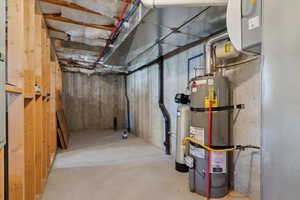 Unfinished below grade area featuring newer water heater and a water softener and plumbing for 3rd bathroom