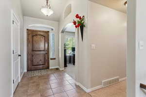 Entrance foyer featuring arched walkways and tile patterned floors