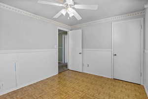 Spare room with a wainscoted wall and ceiling fan