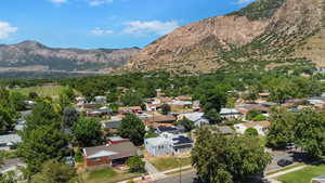 Aerial view of property and surrounding area with mountains and nearby suburban area