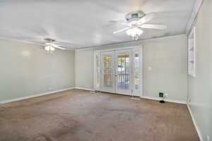 Unfurnished room featuring french doors, a ceiling fan, carpet floors, and ornamental molding
