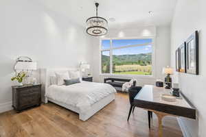 Bedroom with light wood-style floors and a chandelier
