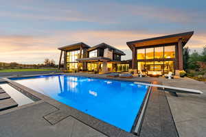 Swimming pool with a diving board, a patio, and an outdoor hangout area
