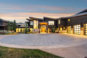 Modern home featuring decorative driveway, stone siding, and an attached garage